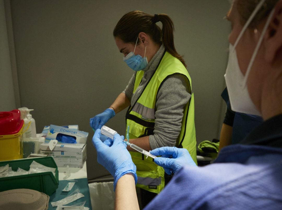 Dos trabajadoras sanitarias, en un dispositivo para administrar la vacuna contra la COVID-19 a profesionales sociosanitarios, en Pamplona, Navarra (España), a 29 de diciembre de 2020.