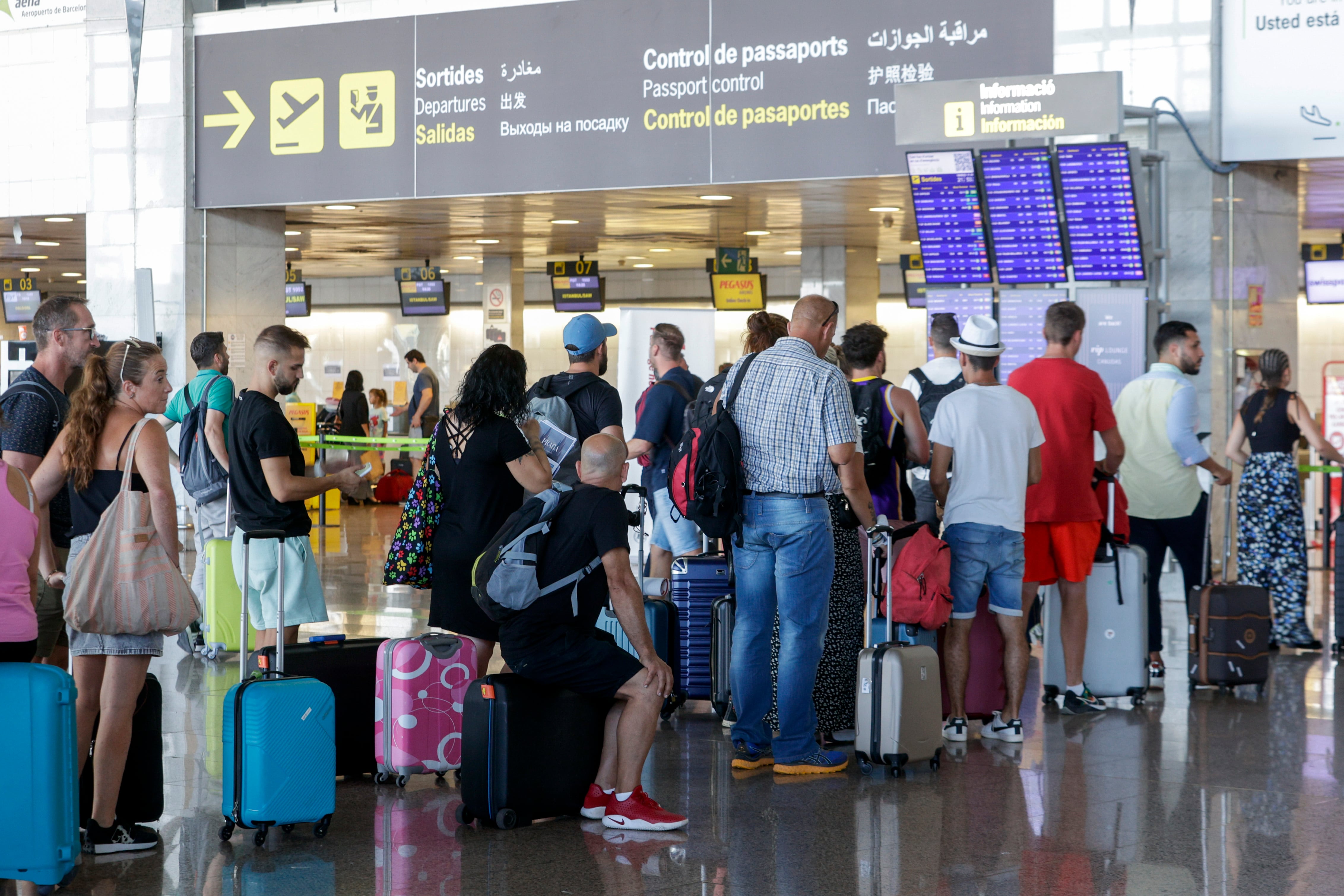 EL PRAT DE LLOBREGAT (BARCELONA), 15/08/2022.- Varios pasajeros hacen cola ante uno de los mostradores de facturación en la Terminal 2 del Aeropuerto de Barcelona-El Prat este lunes. La primera de las cuatro jornadas de huelga a la que están convocados esta semana los tripulantes de cabina de pasajeros de Ryanair en España por los sindicatos USO y Sitcpla ha dejado, de momento, seis vuelos cancelados y 78 retrasos. EFE/ Quique García
