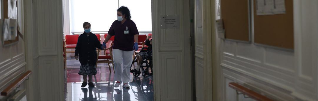 Una gerocultura coge de la mano a una residente de una residencia de mayores