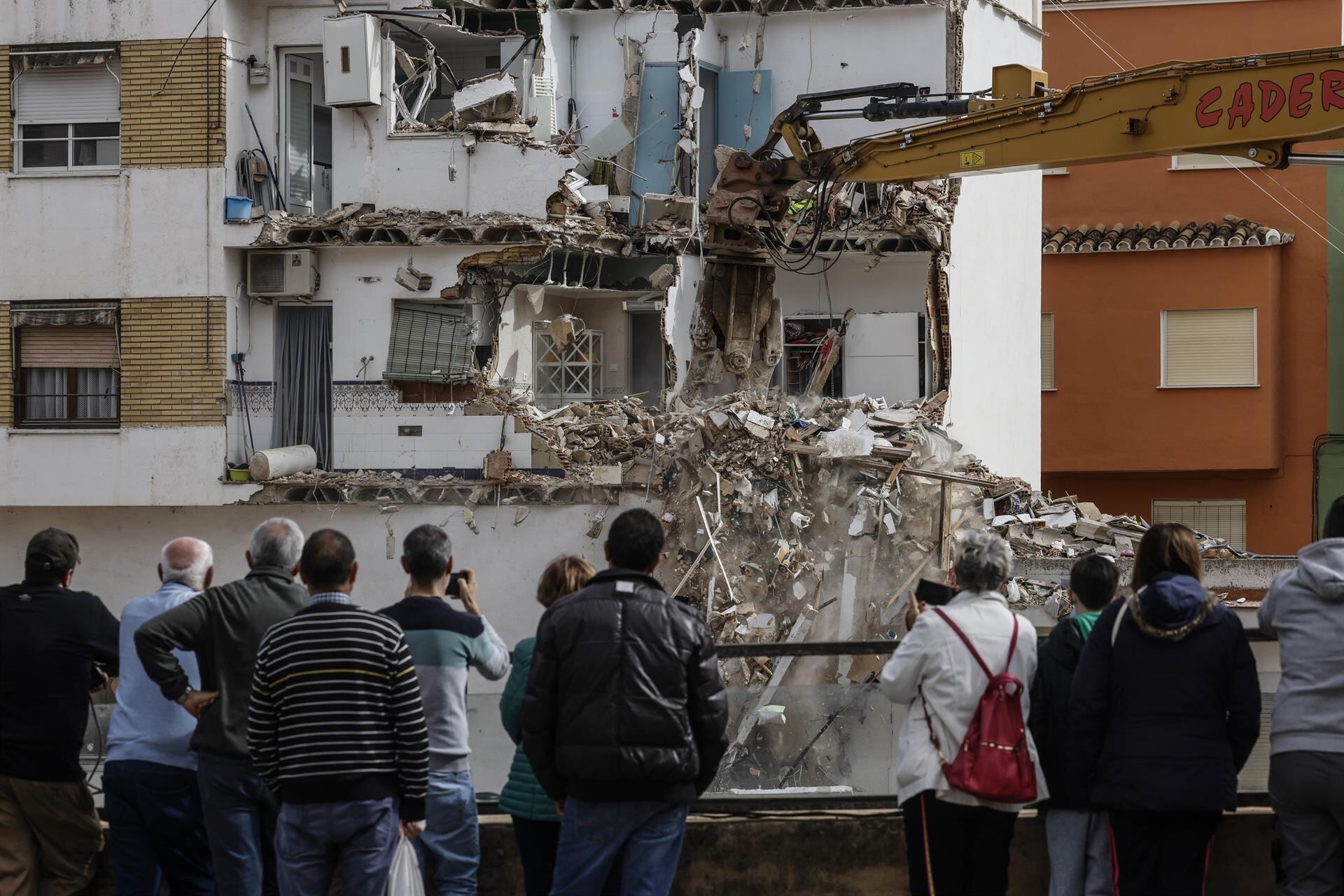 Vecinos observan el derribo de viviendas con maquinaria pesada, a 24 de febrero de 2025, en Chiva