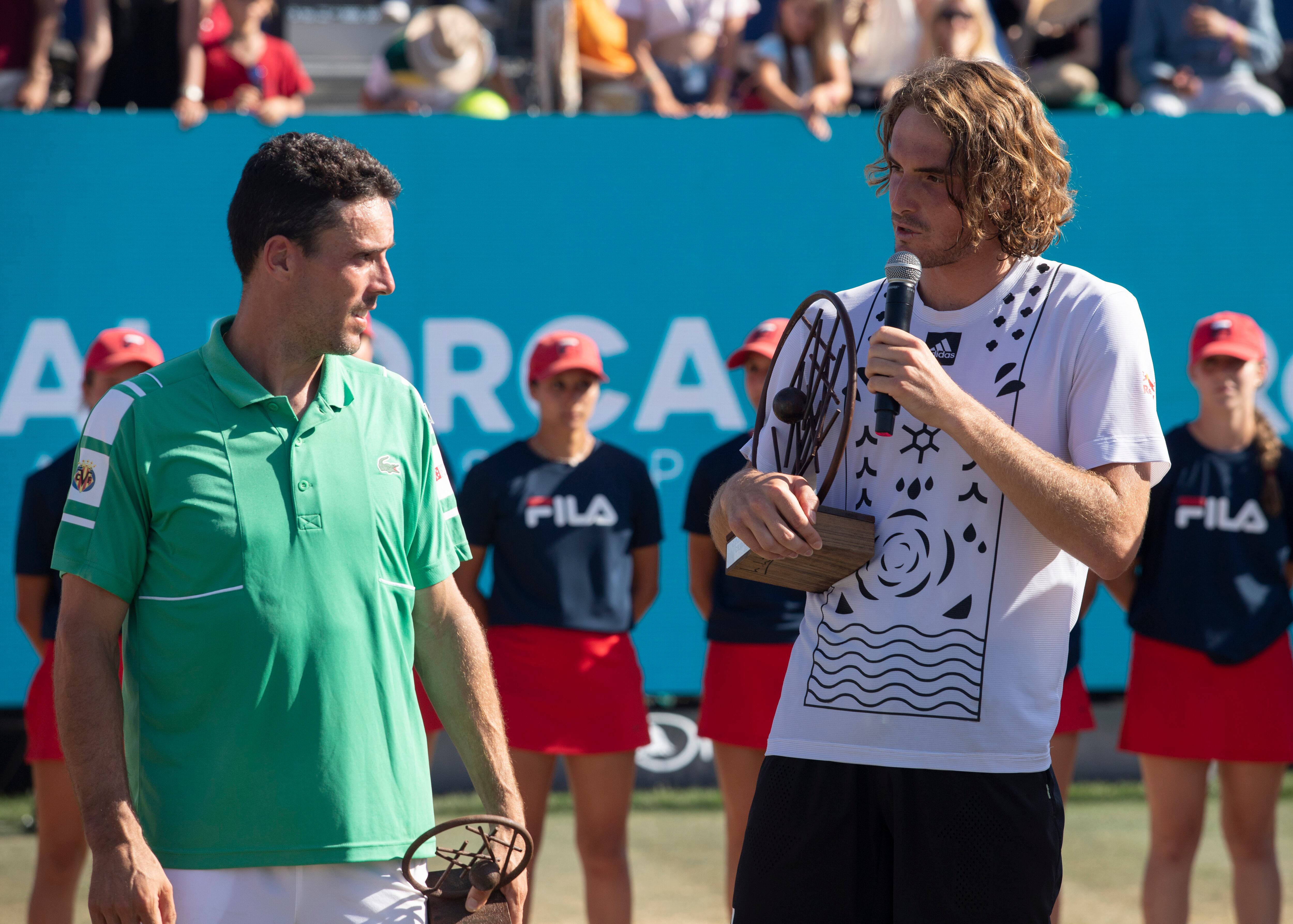 CALVIÁ (MALLORCA), 25/06/2022.- El tenista griego Stefanos Tsitsipas(d) tras imponerse al español Roberto Bautista (i) en un encuentro correspondiente a la final individual del Mallorca Championships, disputado este sábado en las pista principal sobre hierba del Mallorca Country Club en Santa Ponsa, Mallorca. EFE/ Jordi Avellà
