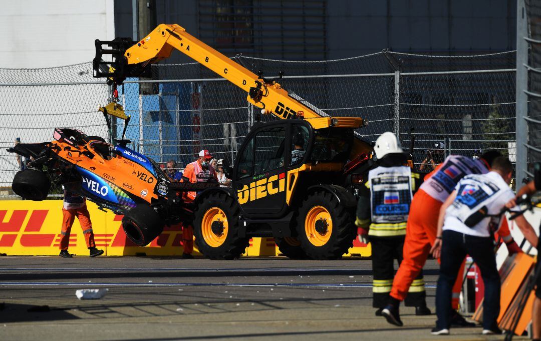 Técnicos del circuitos recogen el monoplaza de Sainz. 