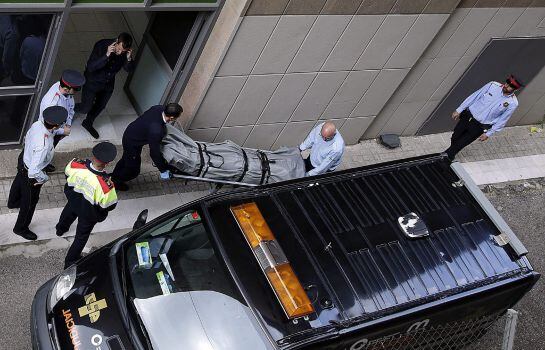 Miembros de los servicios funerarios de Barcelona y del juzgado de guardia retiran el cadáver del profesor del instituto Joan Fuster.