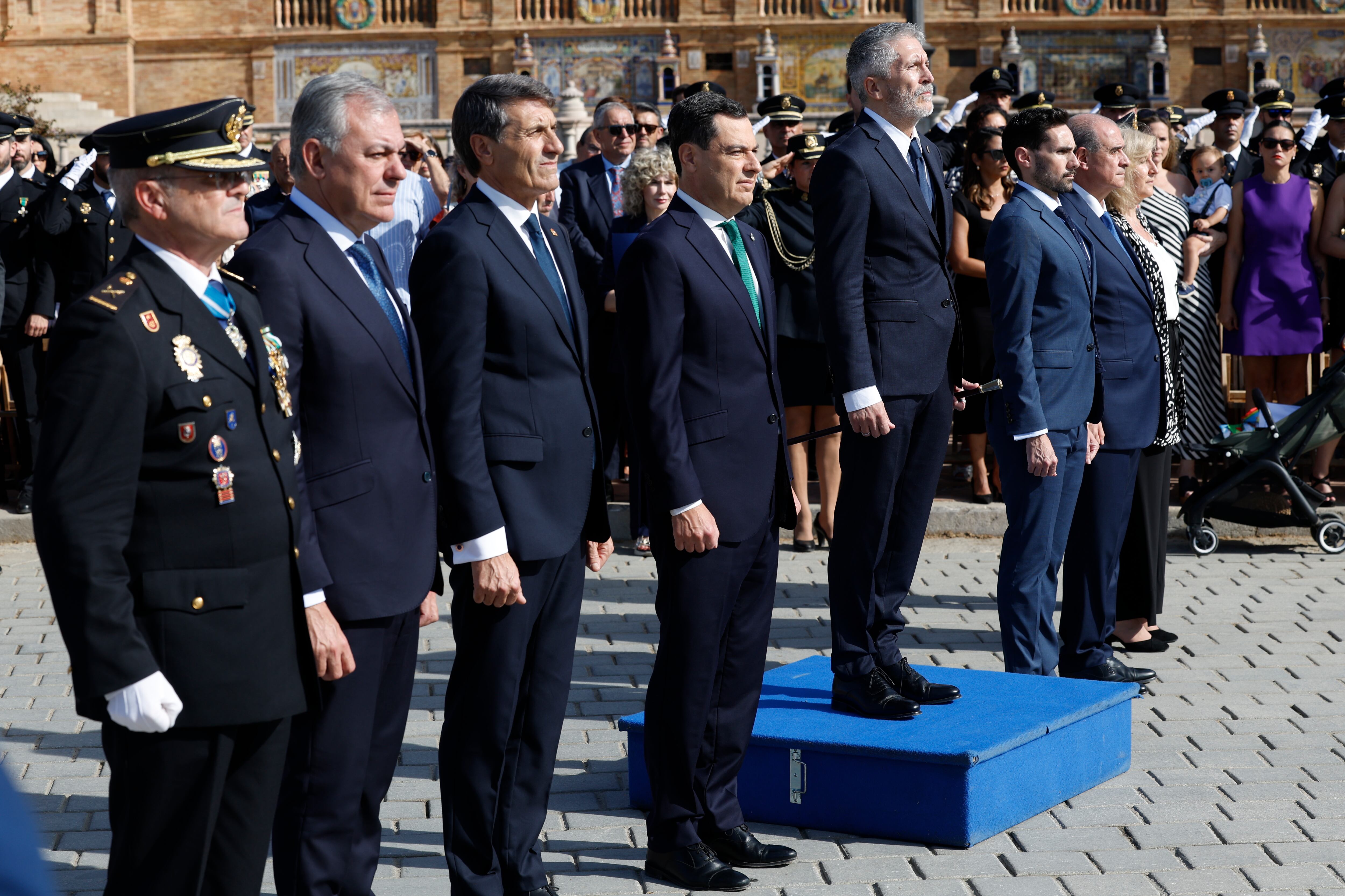 SEVILLA, 02/10/2024.- El ministro del Interior, Fernando Grande-Marlaska, acompañado del presidente de la Junta de Andalucía, Juanma Moreno; el delegado del Gobierno en Andalucía, Pedro Fernández; el alcalde de Sevilla, José Luis Sanz; el jefe Superior de Policía de Andalucía Occidental, Andrés Martín Garrido, y el director general de la Policía Nacional, Francisco Pardo, durante el acto central organizado por el Día de la Policía que ha presidido este miércoles en la Plaza de España en Sevilla.EFE/Julio Muñoz