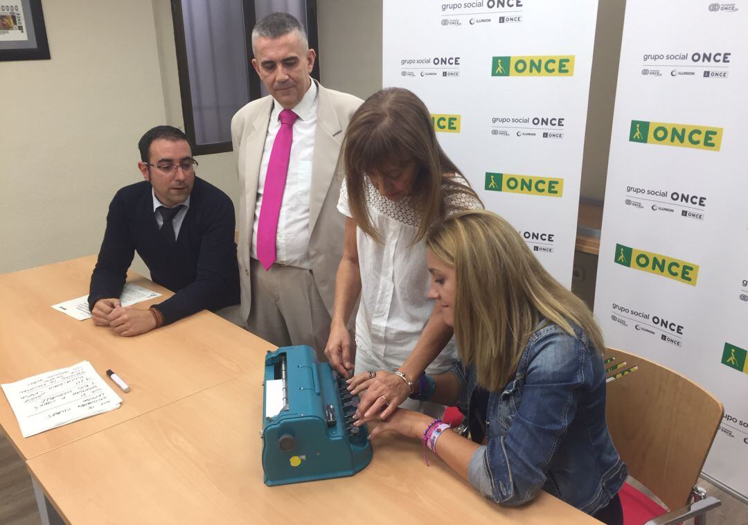 La concejala de Servicios Sociales de Cuenca, Esther Barrios (d), aprende a escribir a máquina en Braille junto a responsables de la ONCE y de HC Hostelería