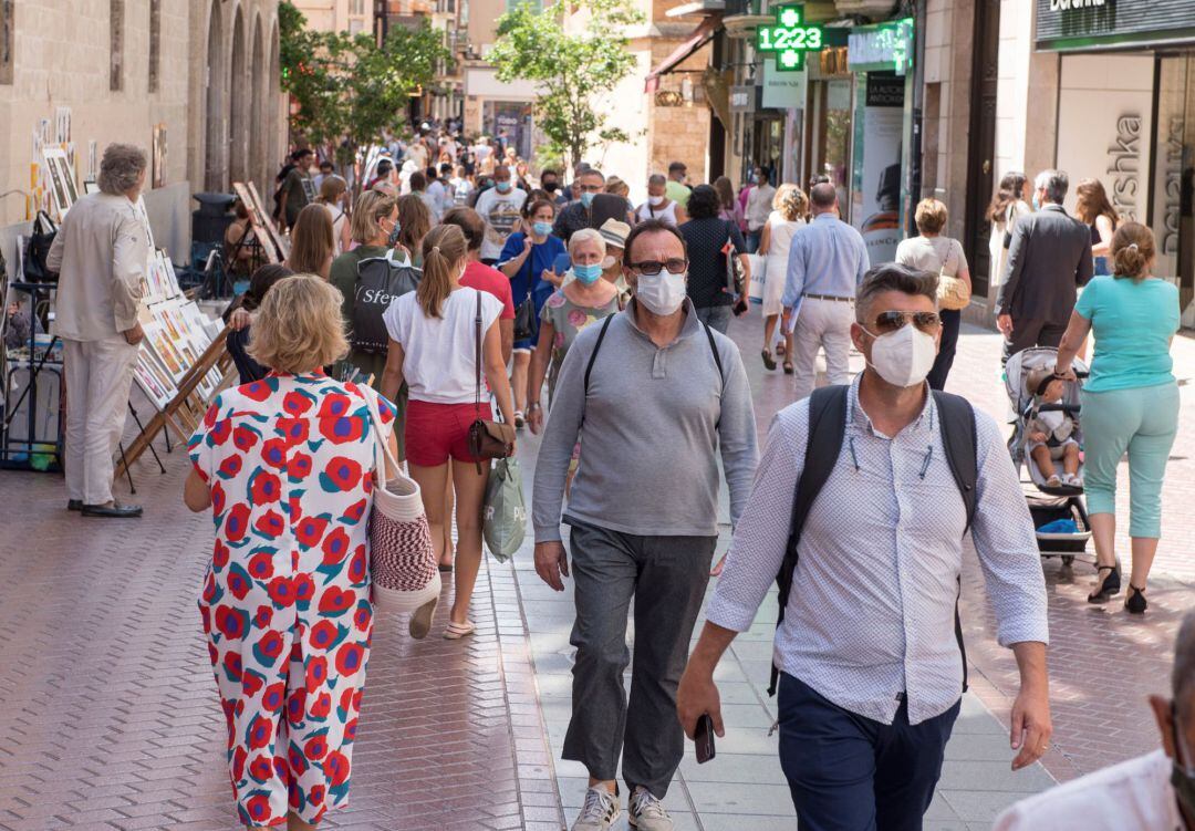 Transeúntes se protegen con mascarillas por las calles de Palma
