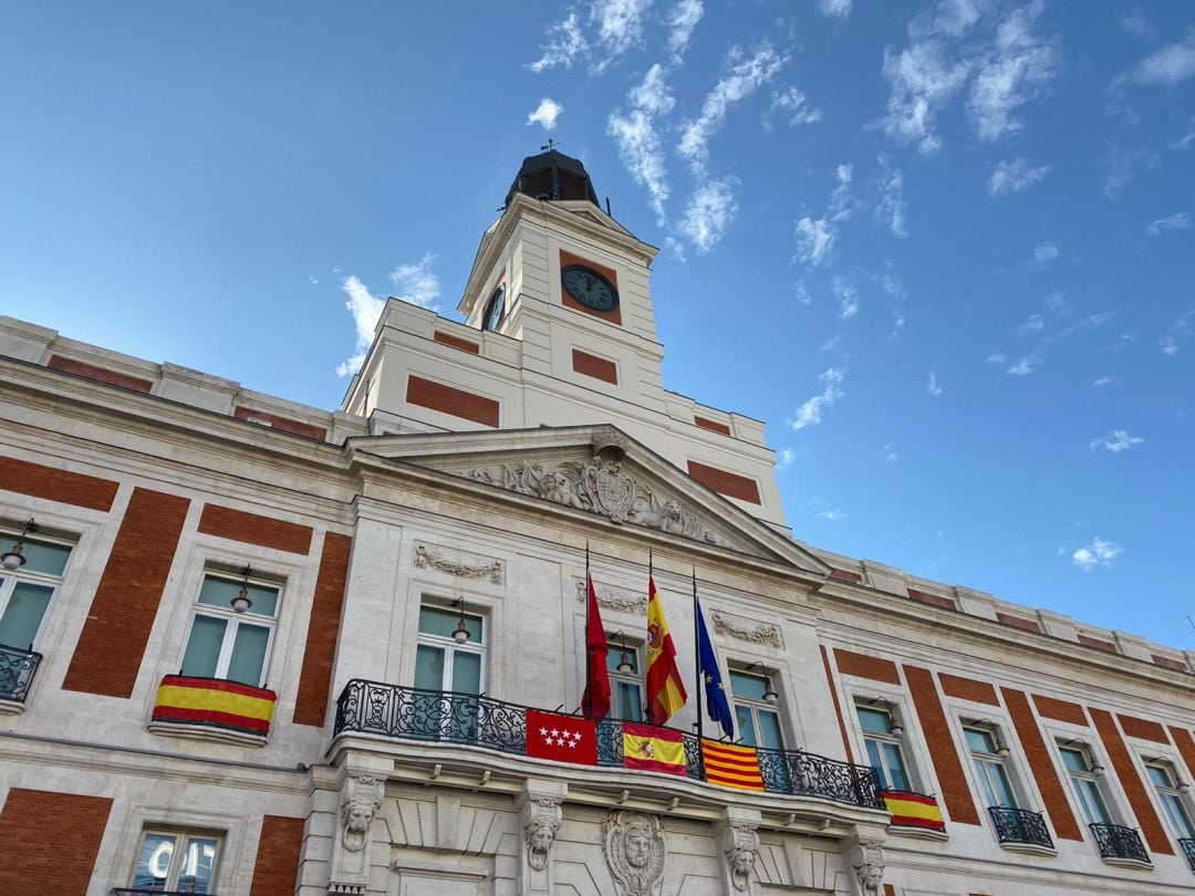 Las banderas de Madrid, España y Cataluña en el balcón de la Real Casa de Correos.