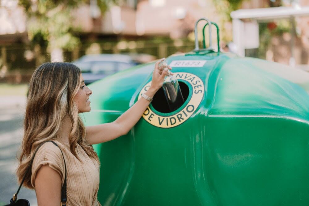 Imagen de archivo de una usuaria depositando una botella vacía en un contenedor de vidrio en Alicante