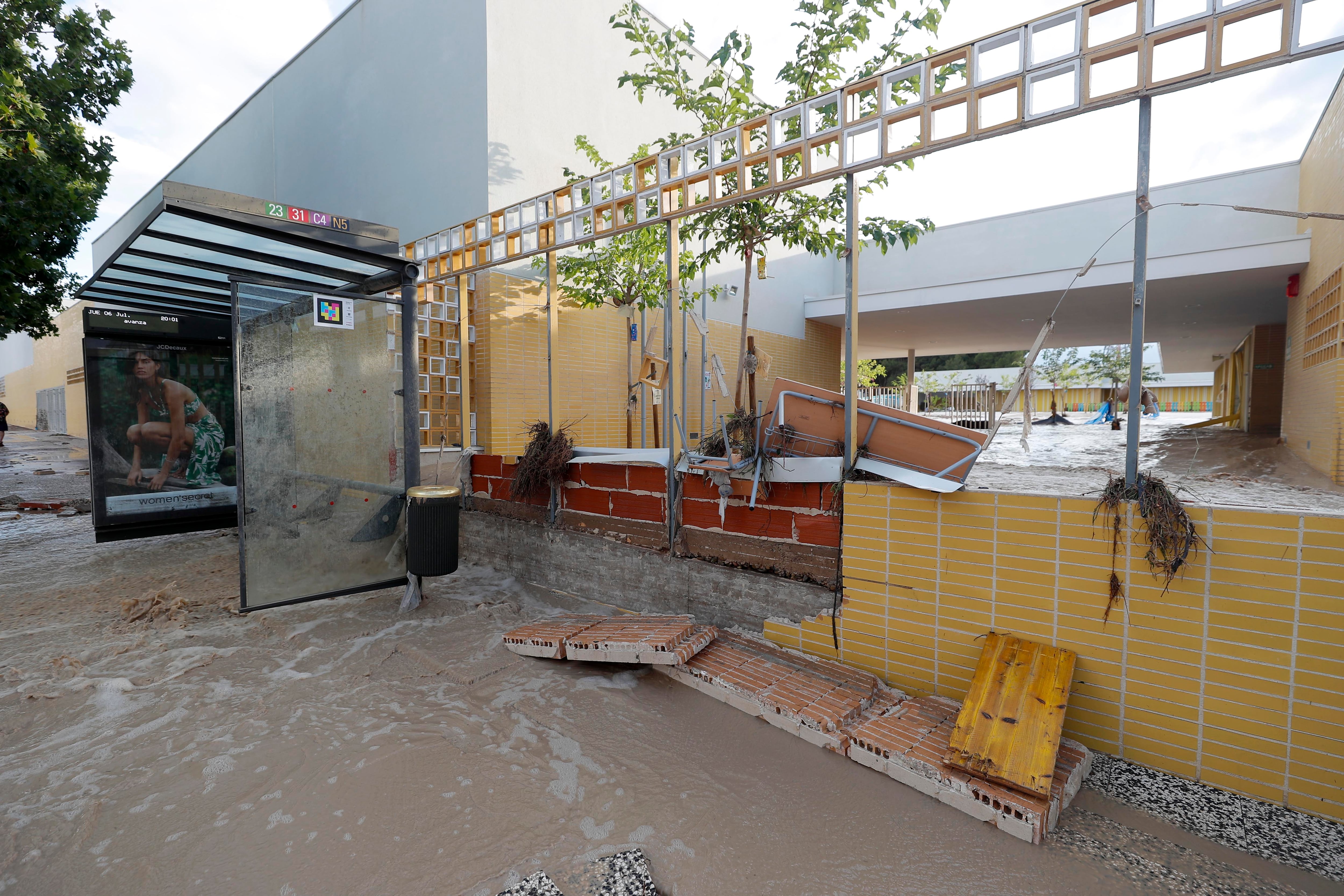 Un gran torrente de agua derriba la tapia de un colegio del barrio de Puerto Venecia tras la tormenta de este jueves en Zaragoza