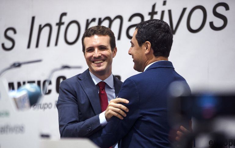 El vicesecretario de Comunicación del Partido Popular y cabeza de lista al Congreso de los Diputados por Ávila, Pablo Casado (i), abraza al presidente del PP-A, Juanma Moreno, durante su participación en un desayuno informativo en Málaga. 