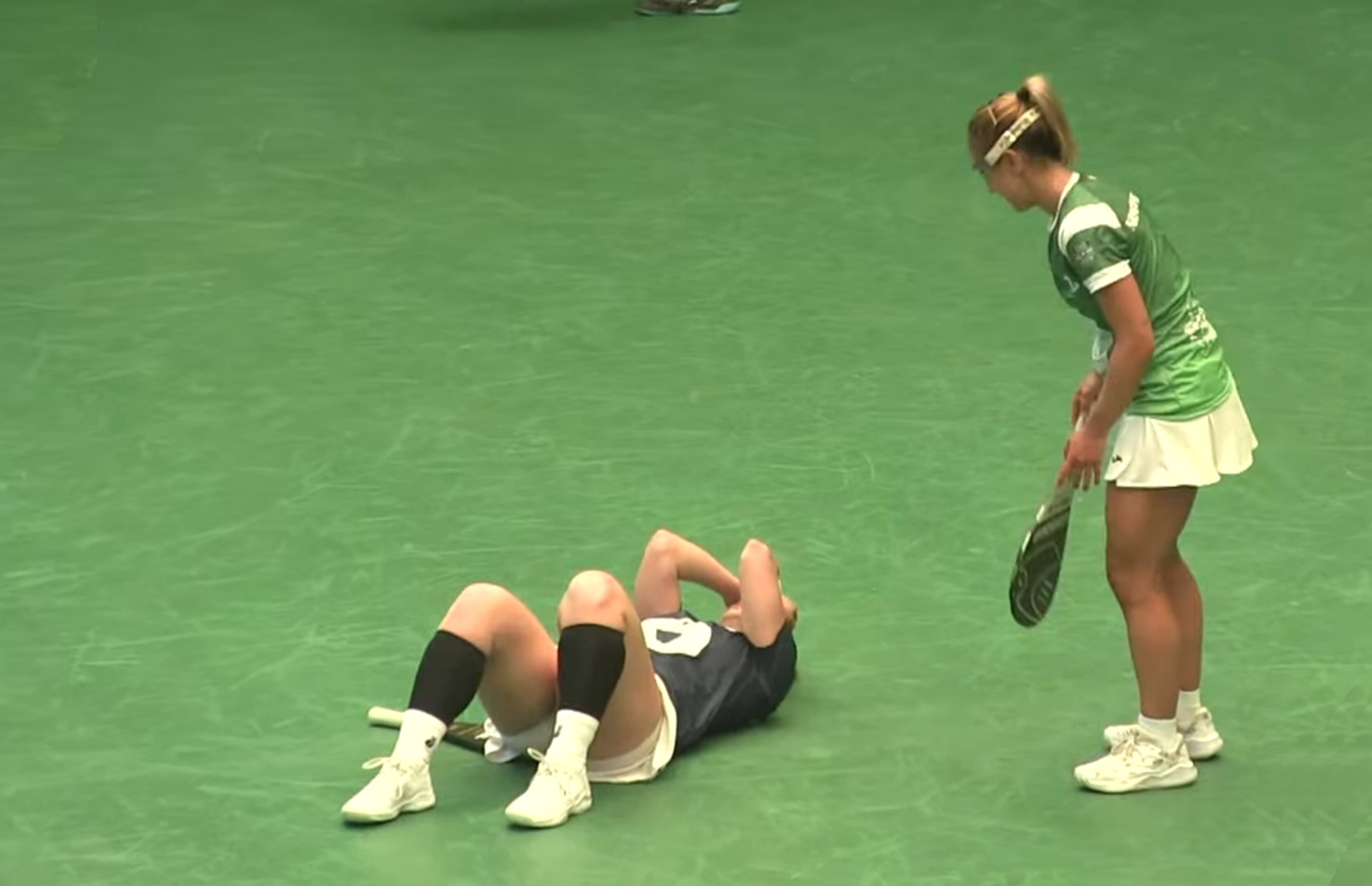 Nagore Martín (Euskadi) observa a Magdalena Muñoz (Chile), tendida en el suelo exhausta, tras finalizar el partido por la medalla de bronce