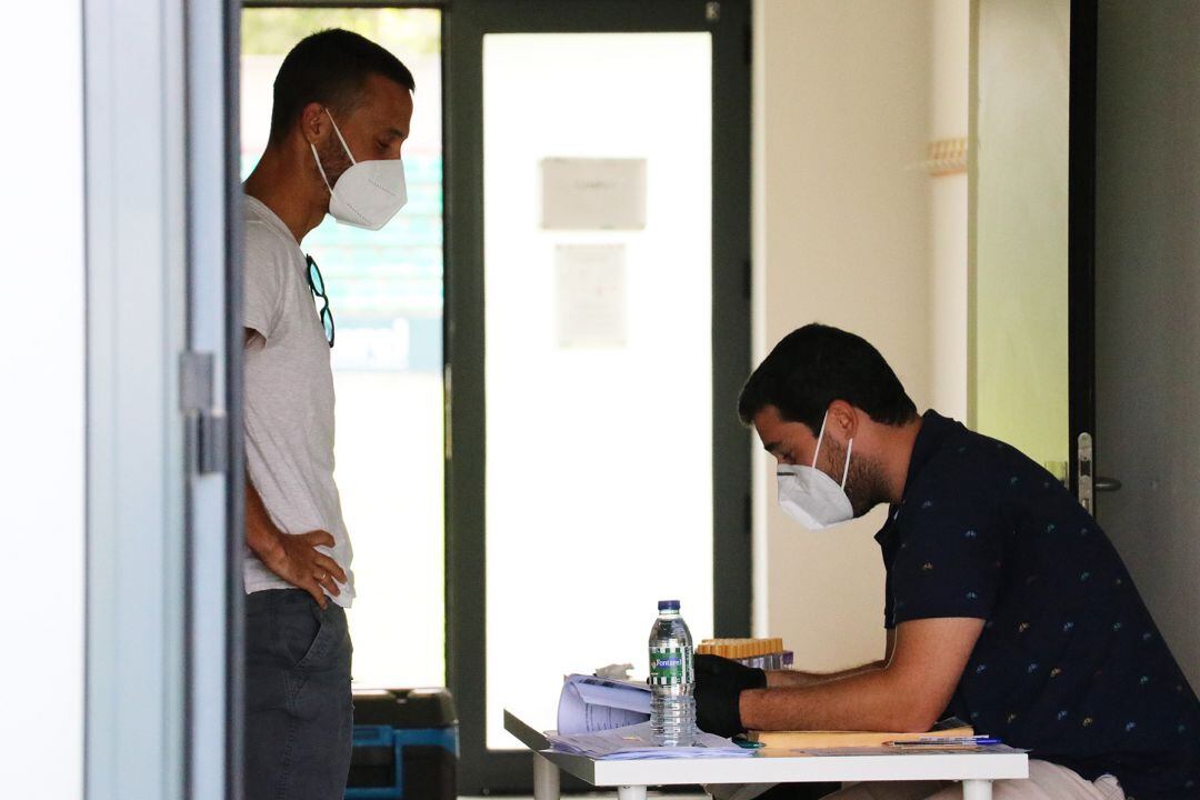 Los futbolistas del Betis comenzaron ayer la actividad sometiéndose a los test PCR. En la imagen, el cántabro Canales con uno de los médicos del club