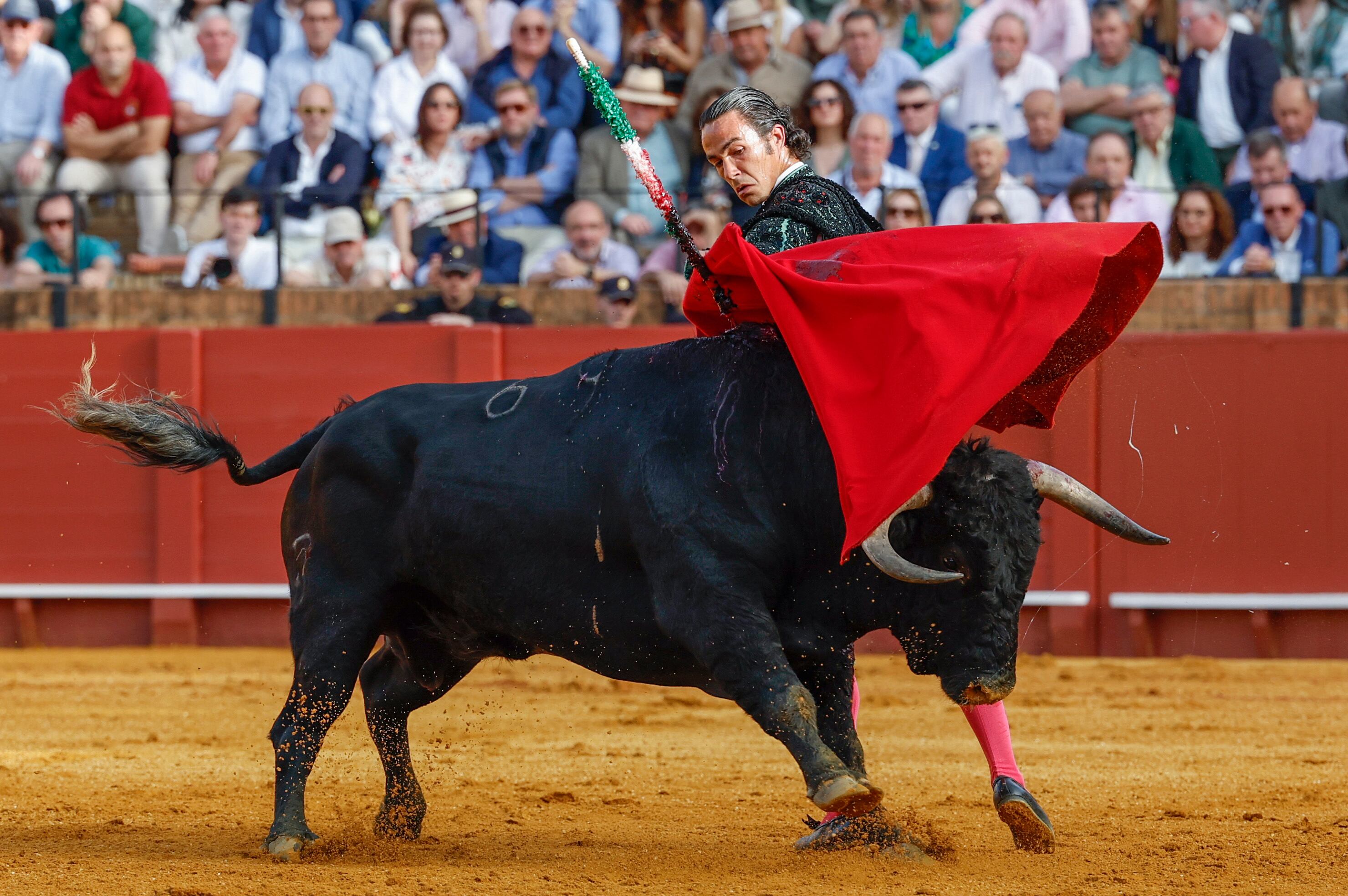 SEVILLA, 07/04/2024.- El diestro Ruiz Muñoz da un pase con la muleta al primero de los de su lote, durante la corrida celebrada este domingo en la plaza de toros de La Maestranza, en Sevilla. EFE/Julio Muñoz
