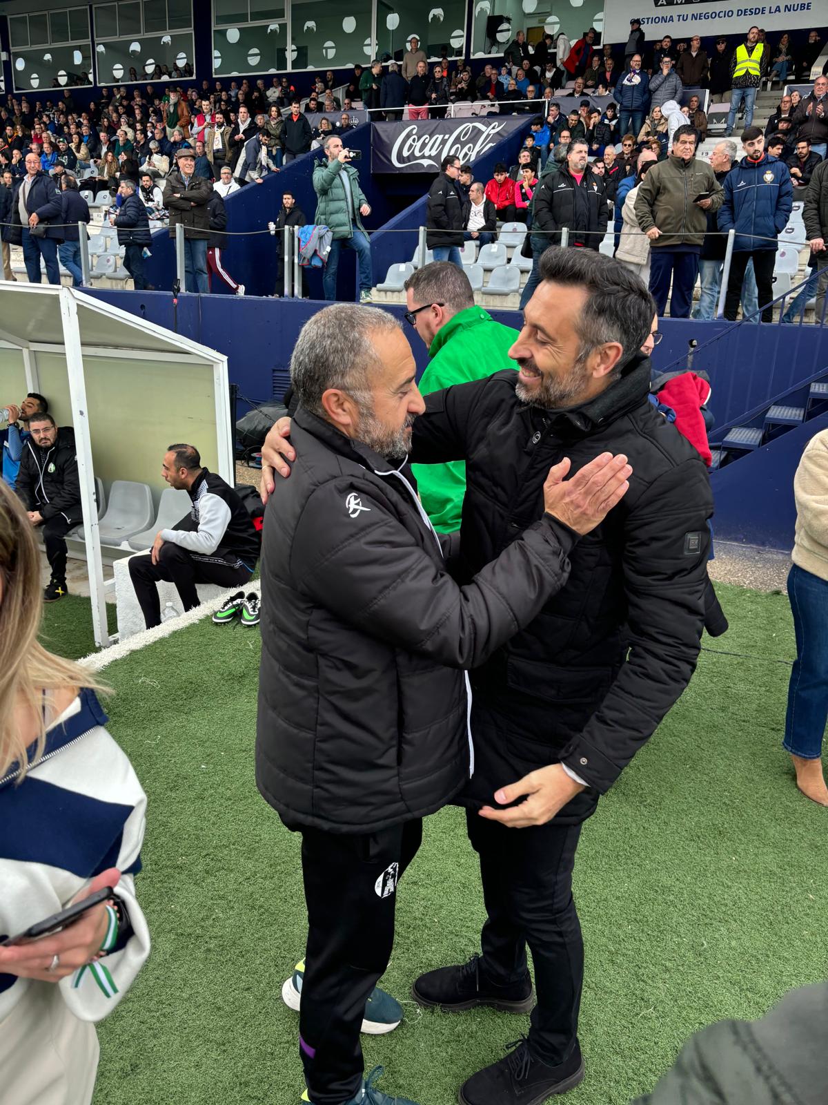 José Jesús Aybar y Manolo Herrero, entrenadores del Atlético Mancha Real y del Real Jaén, se abrazan antes del inicio del encuentro.