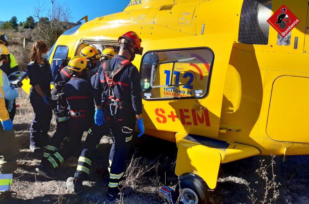 Los bomberos y los sanitarios del SAMU atendiendo a uno de los heridos en el accidente que ha sido trasladado en helicóptero al hospital Virgen de los Lirios de Alcoy.