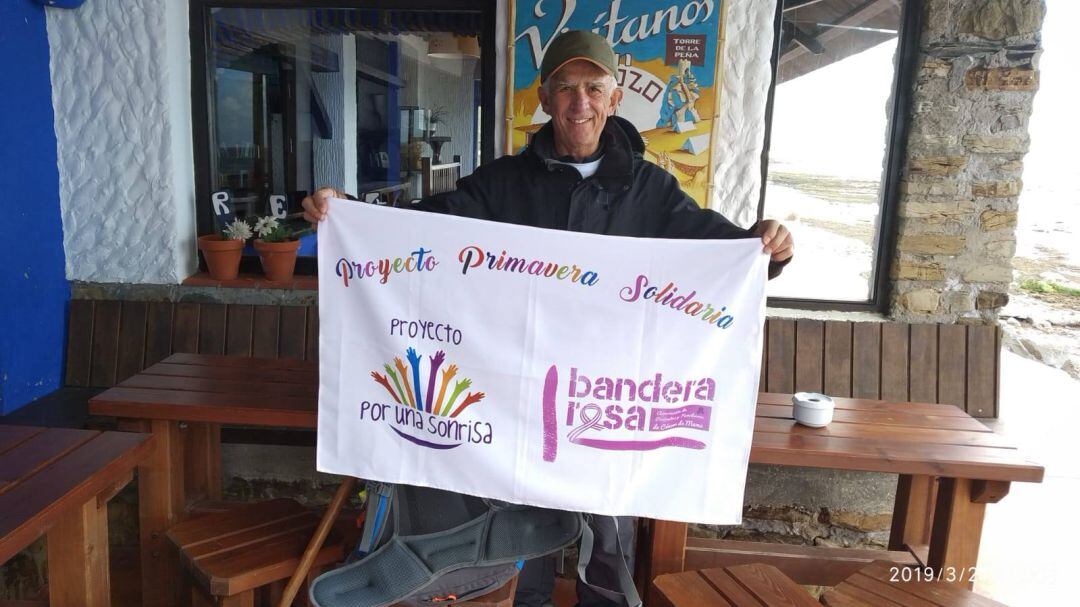 Manuel García hace un alto en su camino y extiende su pancarta solidaria.