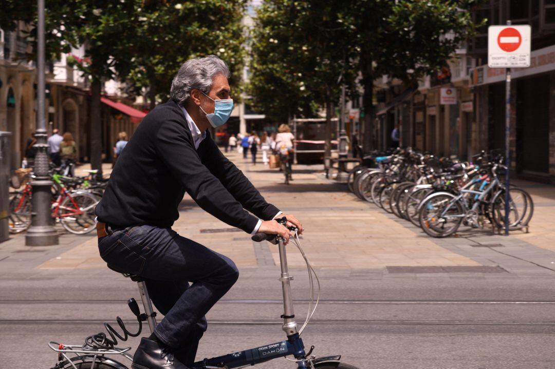 Un hombre pasea en bicicleta con mascarilla por una céntrica calle de Vitoria-Gasteiz, Álava, País Vasco (España), este jueves.