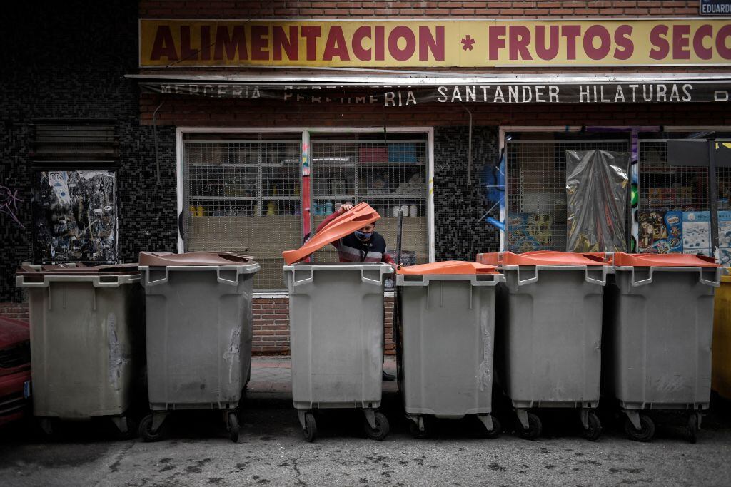 Una persona busca en un contenedor