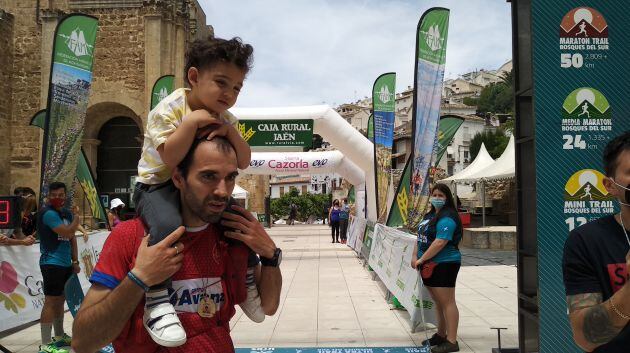 Un niño cruza la linea de meta con su padre