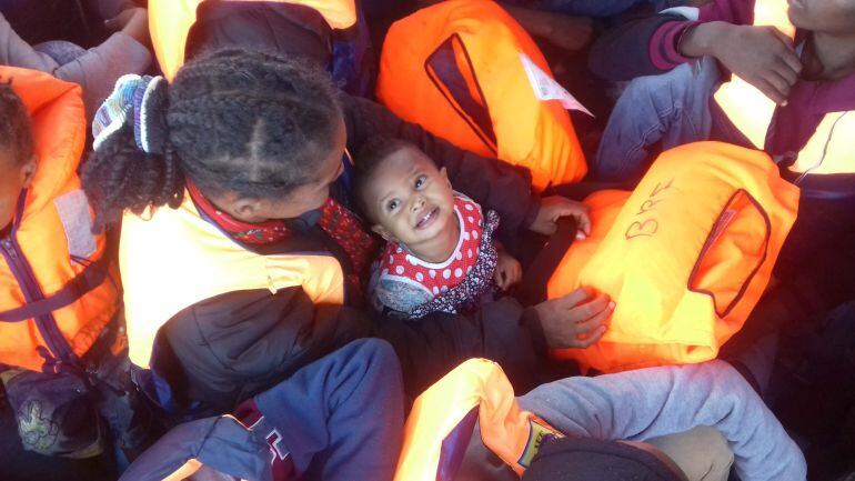 Una niña con su madre en el barco de madera.