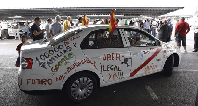 Uno de los taxis que muestran con pintadas su descontento y que junto con centenares de taxistas de toda España han participado hoy en Madrid en la manifestación convocada por el sector, en coincidencia con las 24 horas de huelga de protesta por el intrusismo y la &quot;ilegalidad&quot; de aplicaciones de teléfonos móviles como Uber, convertidas en su principal competencia.