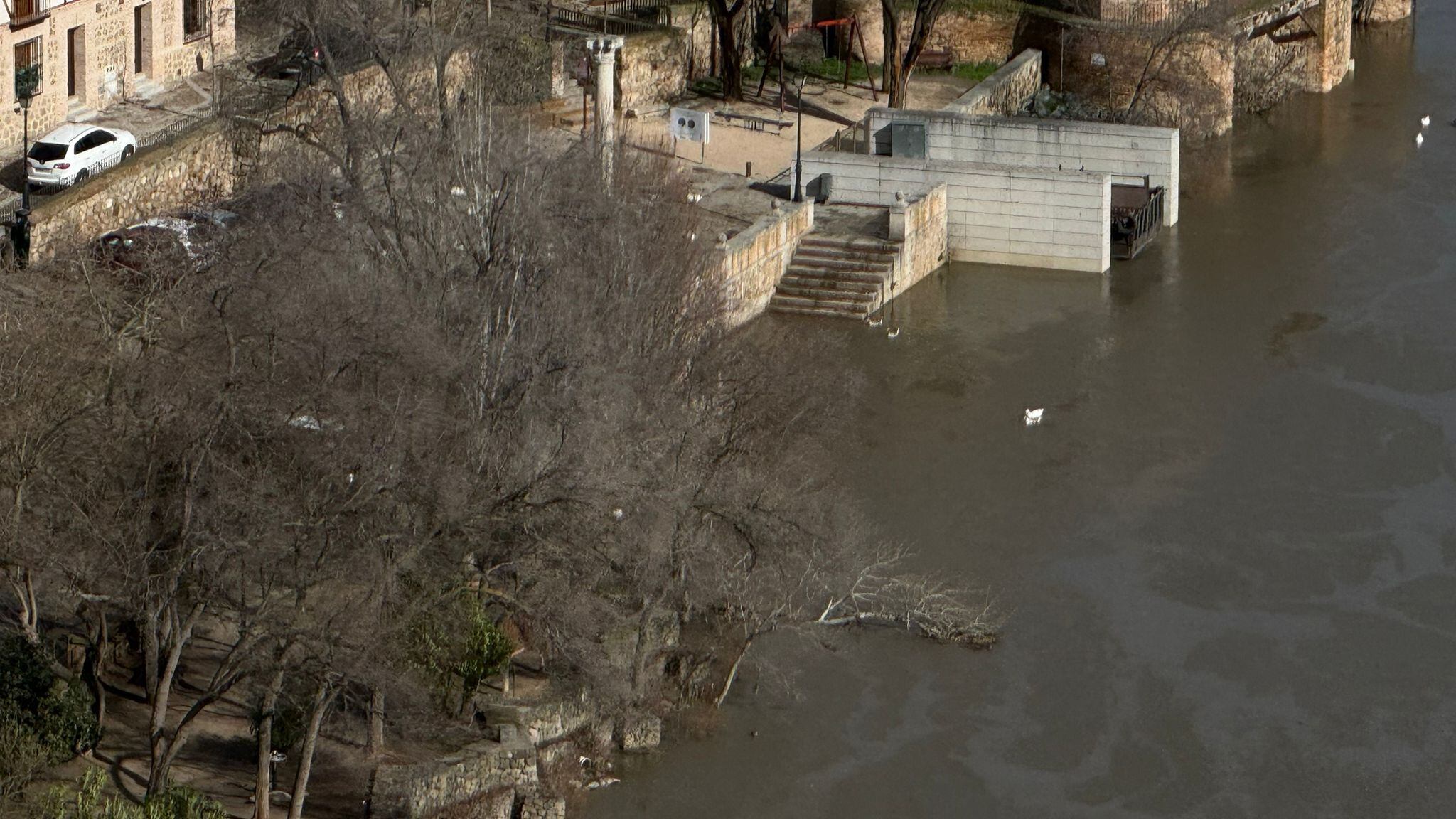 El agua rebosa la base de las escaleras junto a la Casa del Diamantista, en Toledo
