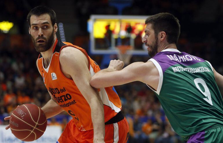 El alero del Valencia Basket Fernando San Emeterio (i) trata de vencer la opsición del base serbio del Unicaja de Málaga Stefan Markovic (d), durante el primer encuentro de los cuartos de final de las eliminatorias de la ACB que disputan esta noche en el 