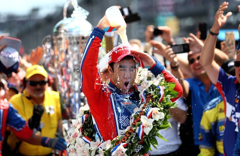 Takuma Sato se echa la tradicional botella de leche por encima