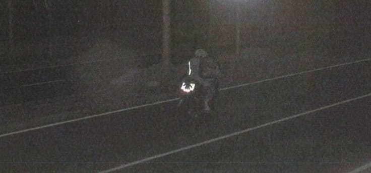 El motorista, posteriormente indentificado, tapando la matrícula