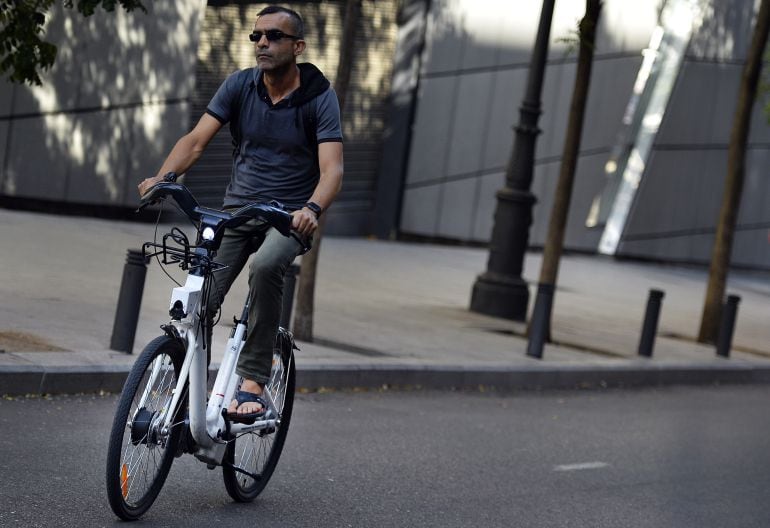 Usuario de bicicleta urbana circulando por una calle en ciudad.