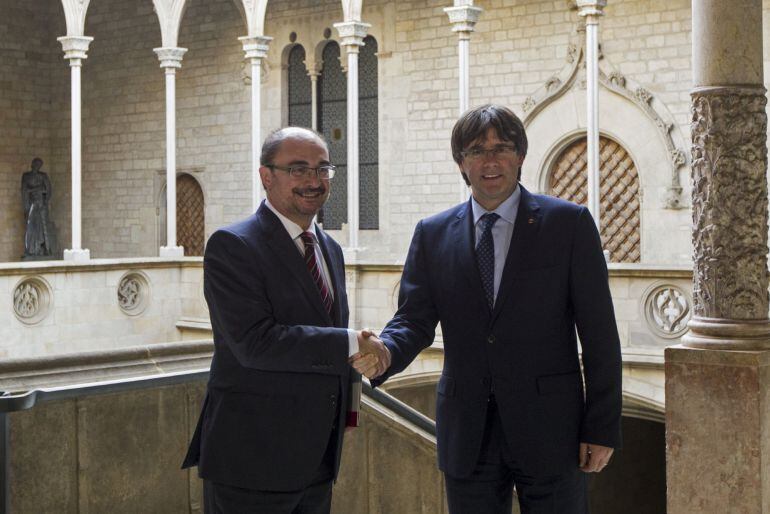  Los presidentes de la Generalitat, Carles Puigdemont, y de Aragón, Javier Lambán, se saludan antes de la reunión que ha mantenido hoy en el Palau de la Generalitat, en Barcelona