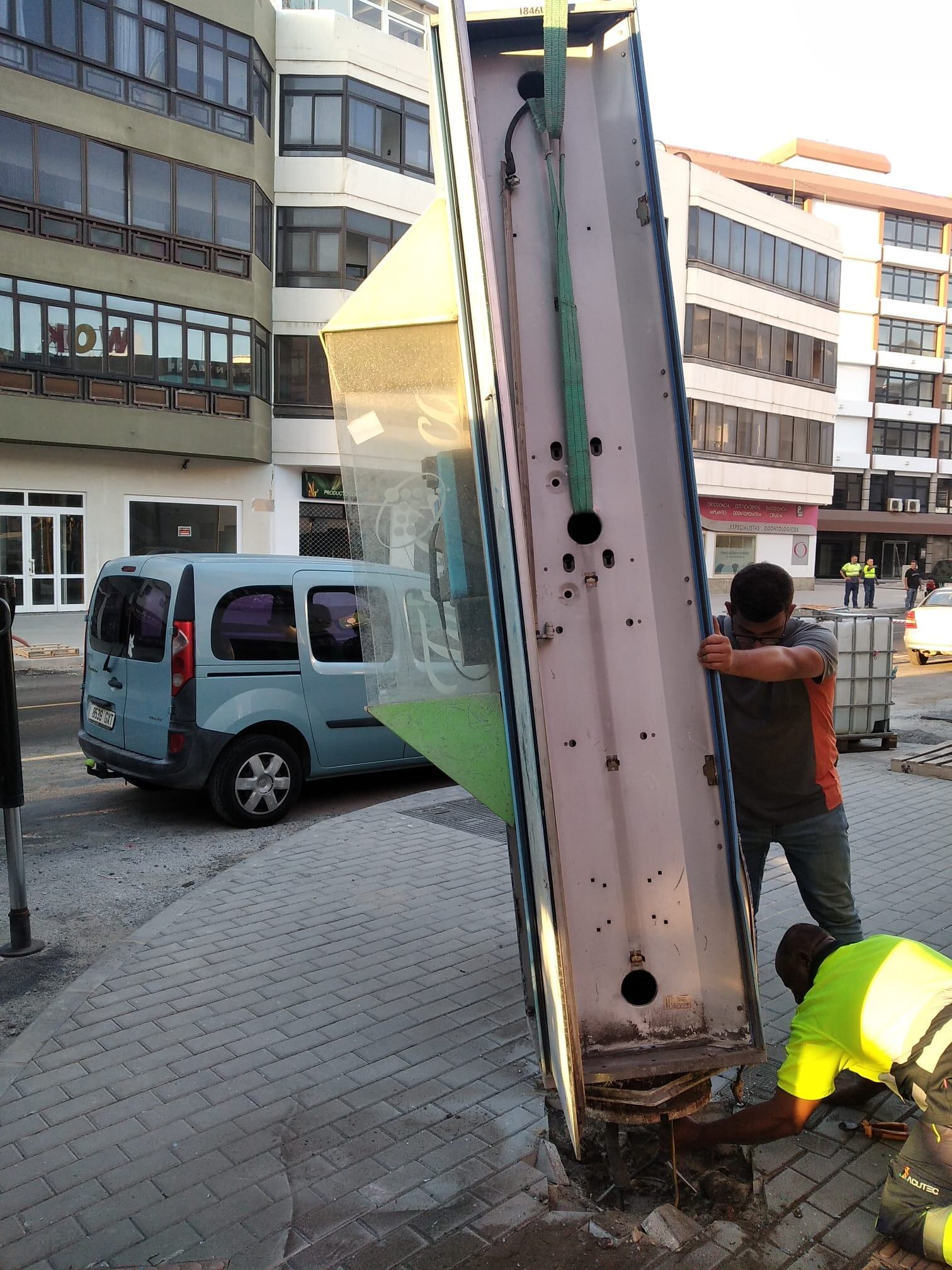 Operarios municipales retirando una cabina telefónica en Arrecife.