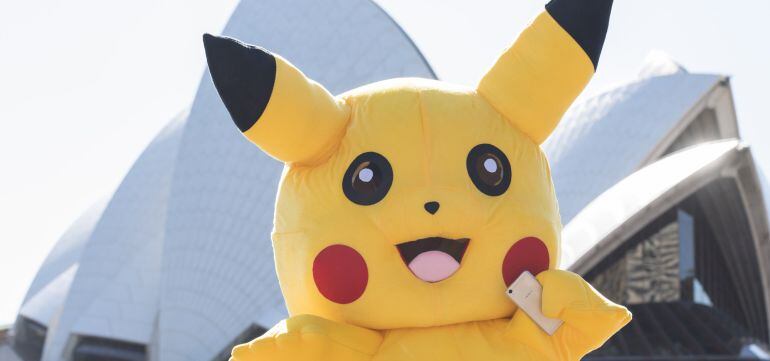 El personaje Pikachu sonríe con un teléfono en la mano en una imagen promocional de Pokémon Go