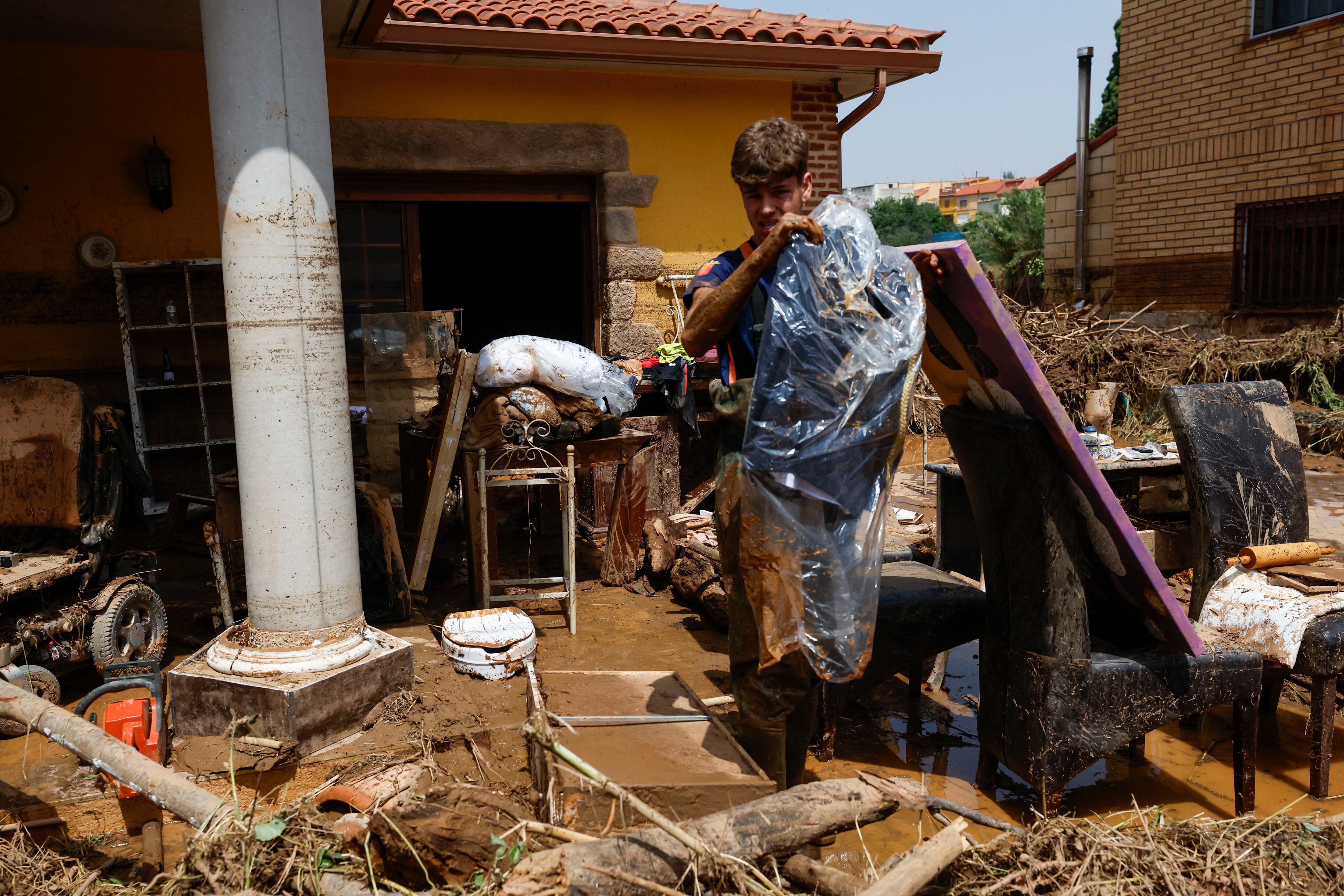 AZUARA (ZARAGOZA), 14/06/2025.- Un joven rescata un traje de comunión de la casa inundada este sábado en la localidad de Azuara (Zaragoza), una de las más afectadas por los cuantiosos daños materiales provocados por las intensas tormentas. Cuatro carreteras permanecen cortadas tras las fuertes tormentas que descargaron a última hora de este viernes en zonas de la provincia de Zaragoza y Teruel y que obligaron al rescate de diez vecinos de la localidad de Letux atrapados por el agua. EFE/ Javier Cebollada