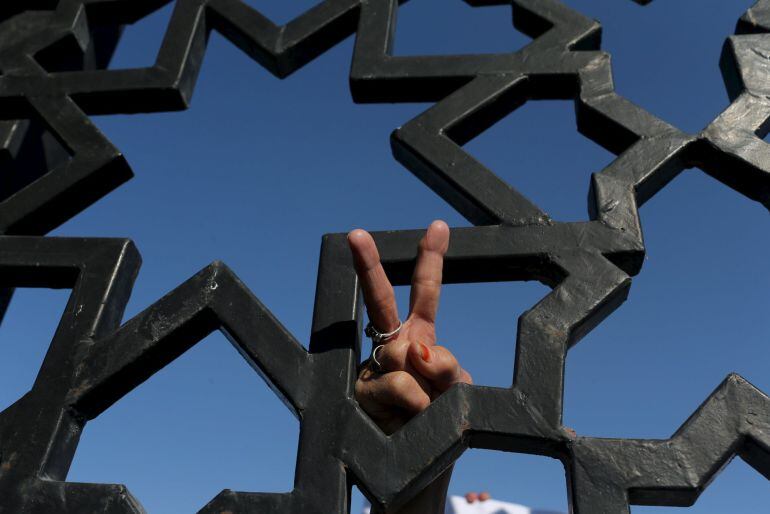 Una mujer palestina hace el signo de la victoria en una manifestación para pedir la apertura de la frontera con Egipto