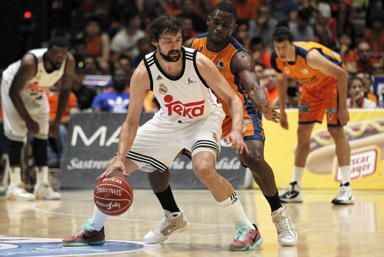 El escolta del Real Madrid Sergio Llull, ante la defensa del alero centroafricano del Valencia Basket, Romain Sato, durante el cuarto partido de semifinales de la Liga Endesa.