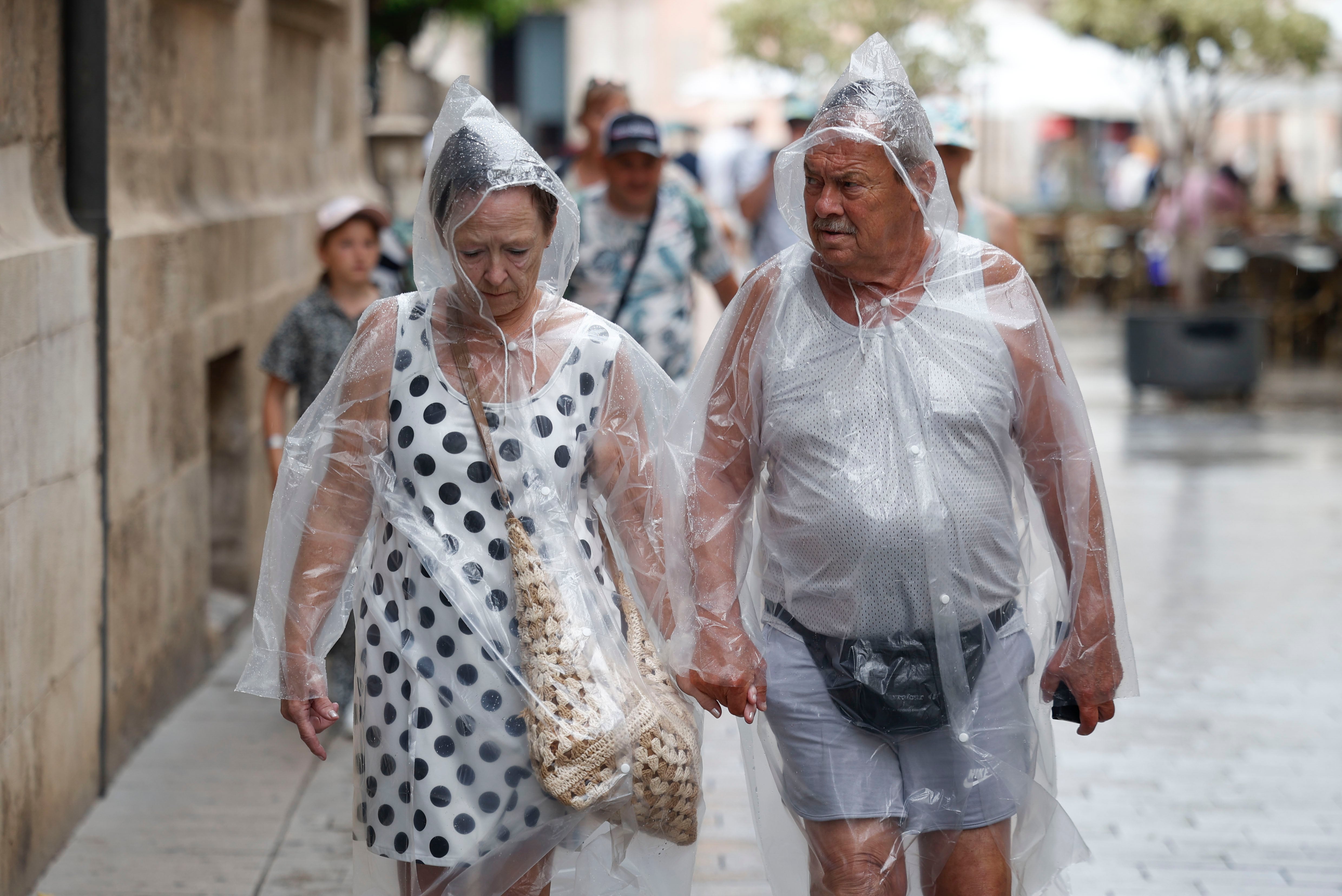 MANISES (VALÈNCIA), 24/07/2025.- Dos personas se protegen de la lluvia este jueves en València. Aemet ha establecido el aviso amarillo por lluvia y tormentas en Alicante y Valencia este jueves y también por fenómenos costeros en Alicante. EFE/ BIEL ALIÑO
