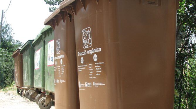 Contenidors de matèria orgànica (en primer terme) i de rebuig