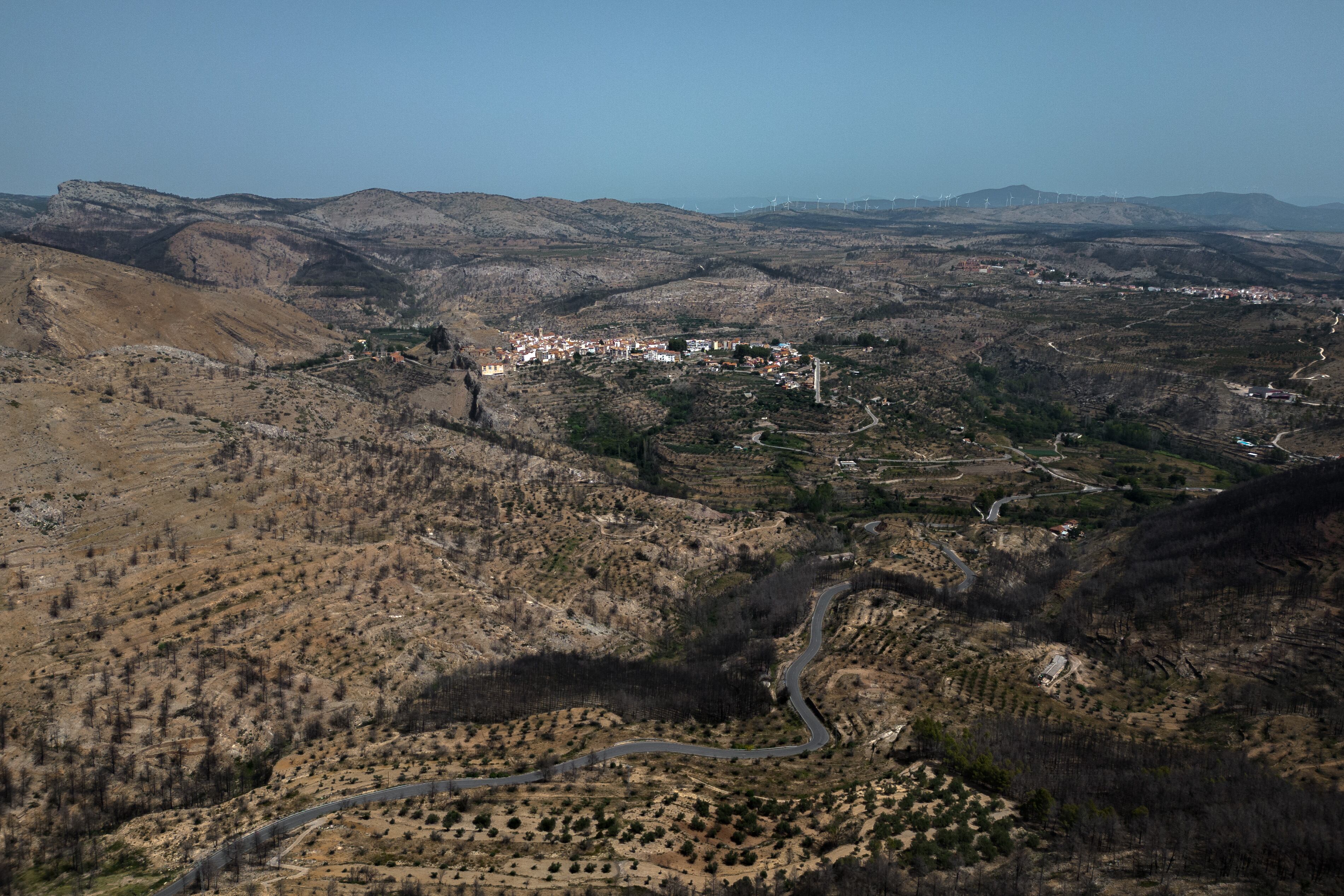 GRAFCVA5100. BEJÍS (CASTELLÓN), 14/08/2023.- Vista aérea, tomada con un dron, de la zona arrasada por el incendio forestal de Bejís. Se cumple un año desde que el pueblo de Bejís, en la comarca castellonense del Alto Palancia, se convirtiera en protagonista por un incendio que arrancó en su término municipal y acabó calcinando 20.000 hectáreas de terreno forestal. EFE/Biel Aliño
