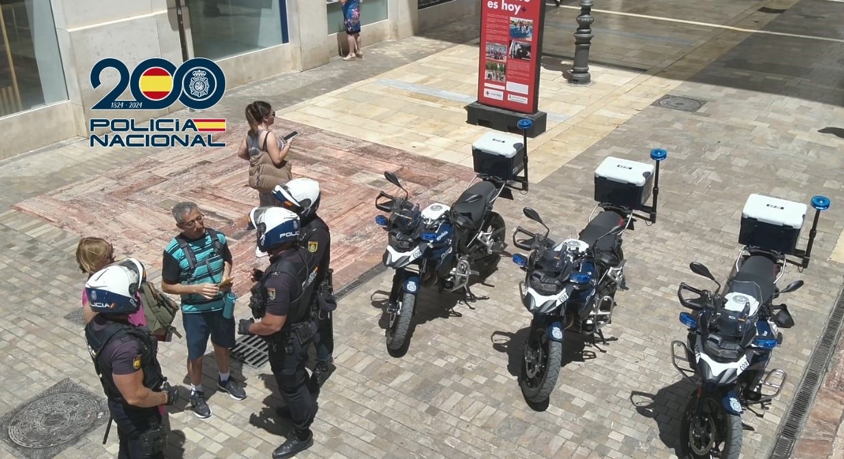 Turistas en el centro de Málaga junto a la Policía Nacional