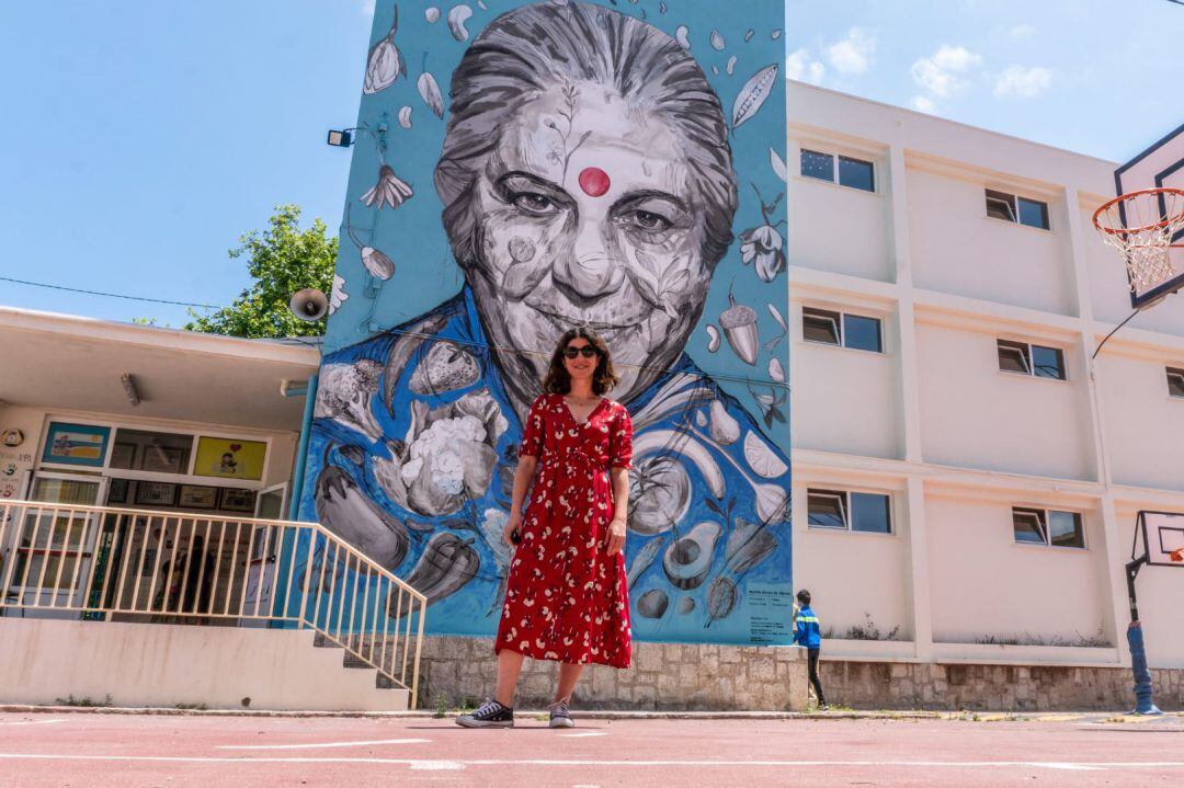 La artista valenciana Marina Puche junto al mural de Vandana Shiva