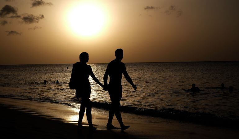 Una pareja camina por una playa