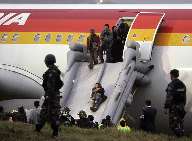 Una mujer salta por la rampa con su hijo en brazos.