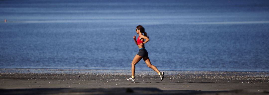 Mujer haciendo deporte en una playa de A Coruña