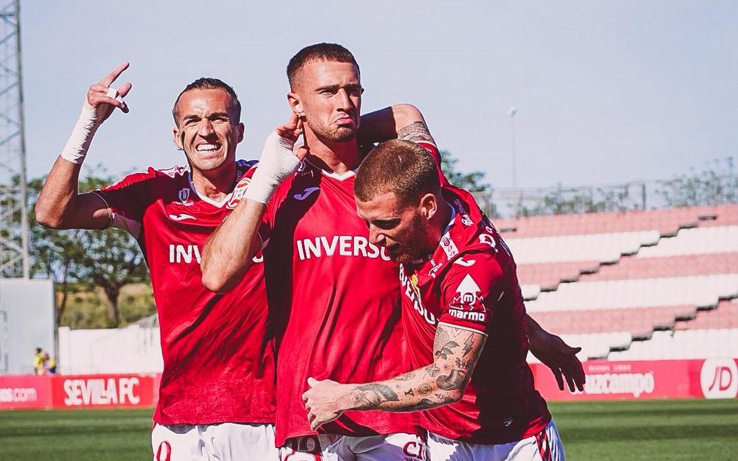 David Flakus Bosilj marca un gol contra el Sevilla Atlético, con la celebración de Pedro Benito (izquierda) y David Vicente (derecha)