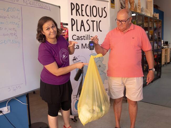 Delia Millán, directora de Fablab Cuenca, recibiendo una bolsa de tapones.
