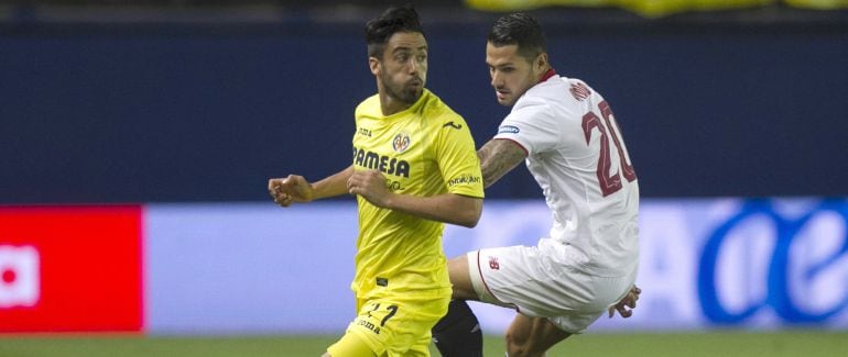 El defensa del Villarreal, Jaume Costa, se lleva el balón ante el centrocampista del Sevilla, Vitolo.