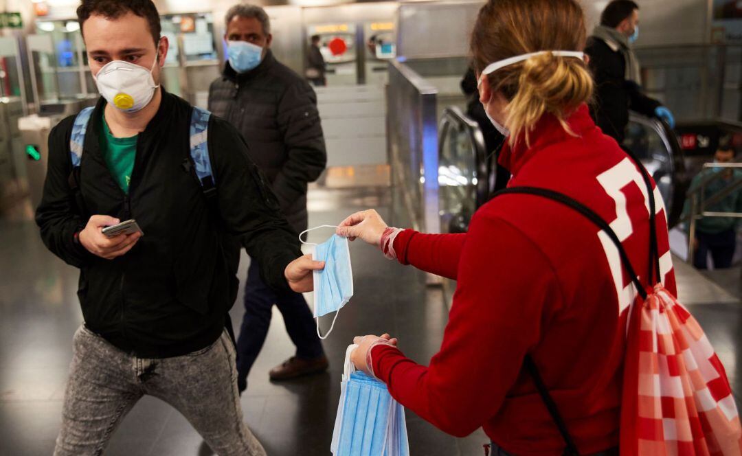 Una voluntaria de Cruz Roja reparte mascarillas desechables.