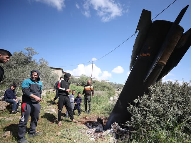 Palestinos inspeccionan los restos de un misil balístico que cayó en la aldea de Haris, en Cisjordania