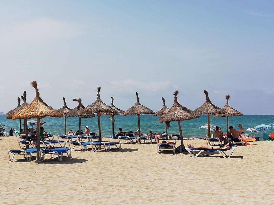 Turistas en hamacas bajo las sombrillas de la Playa de Palma.